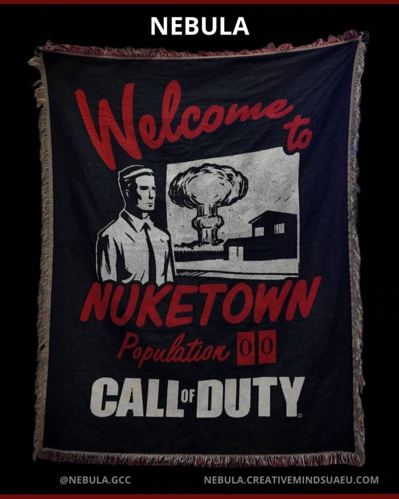 Black decorative tapestry featuring the text “Welcome to Nuketown, Population 00” with a vintage-style illustration of a man standing in front of a nuclear explosion and houses, and “Call of Duty” written at the bottom, displayed against a dark background with “NEBULA” branding at the top.